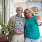 Smiling senior couple enjoying a day out shopping in a sunny Portuguese street.
